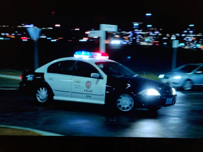 A screenshot from The Very Excellent Mr Dundee showing a Ford AU Falcon dressed up as a LAPD patrol car