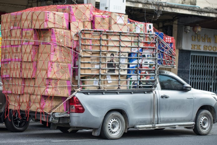 Ute with many boxes hanging out the back and stacked very high